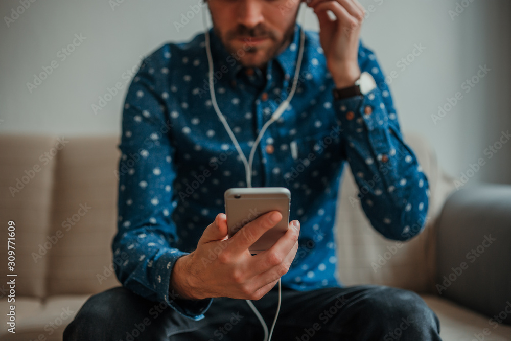 Front view of young man in blue shirt using Zepeel with headphones connected