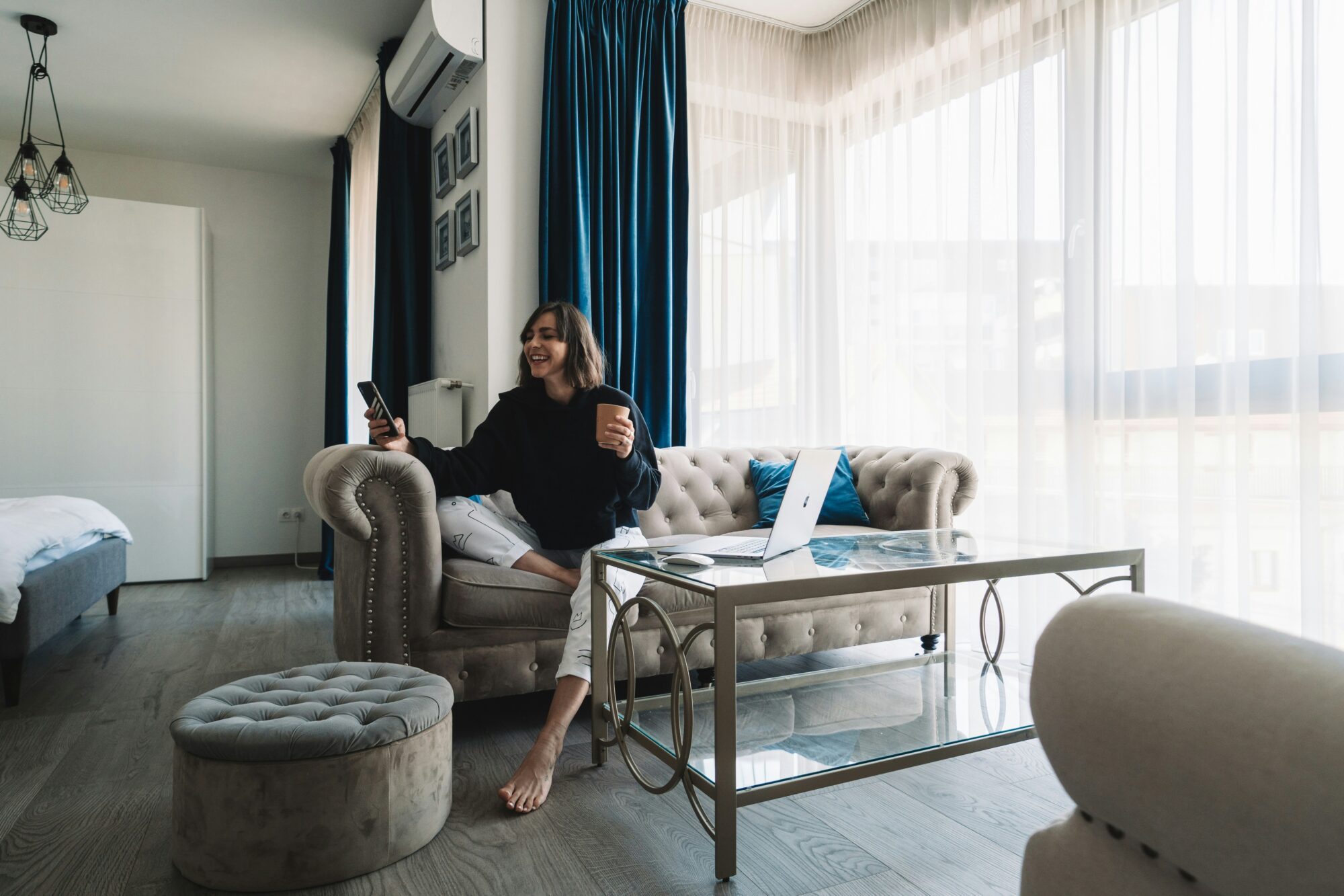 woman in black long sleeve shirt sitting on gray sofa chair using Zepeel for a video chat