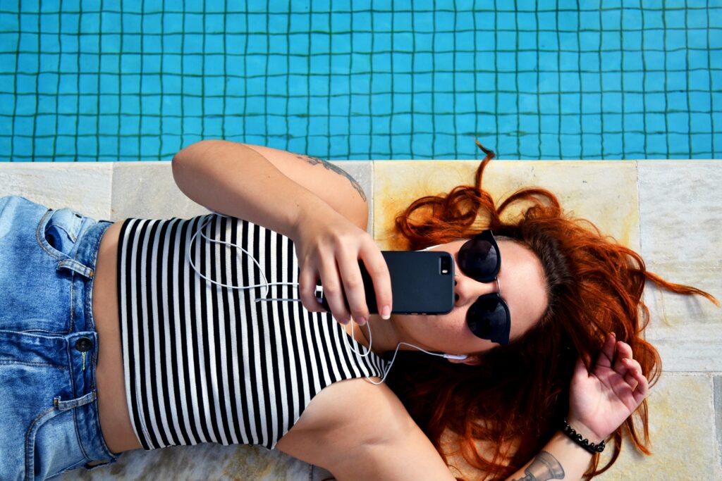 Woman with iPhone on Zepeel dating app by pool