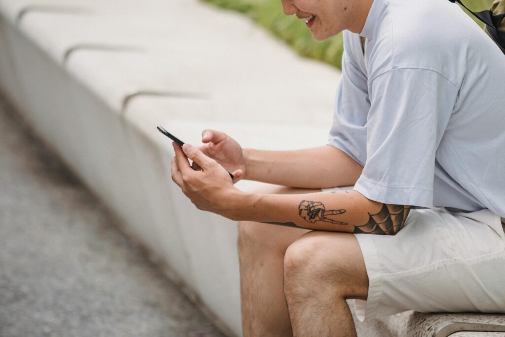 stylish man resting on bench and video messaging on smartphone on Zepeel