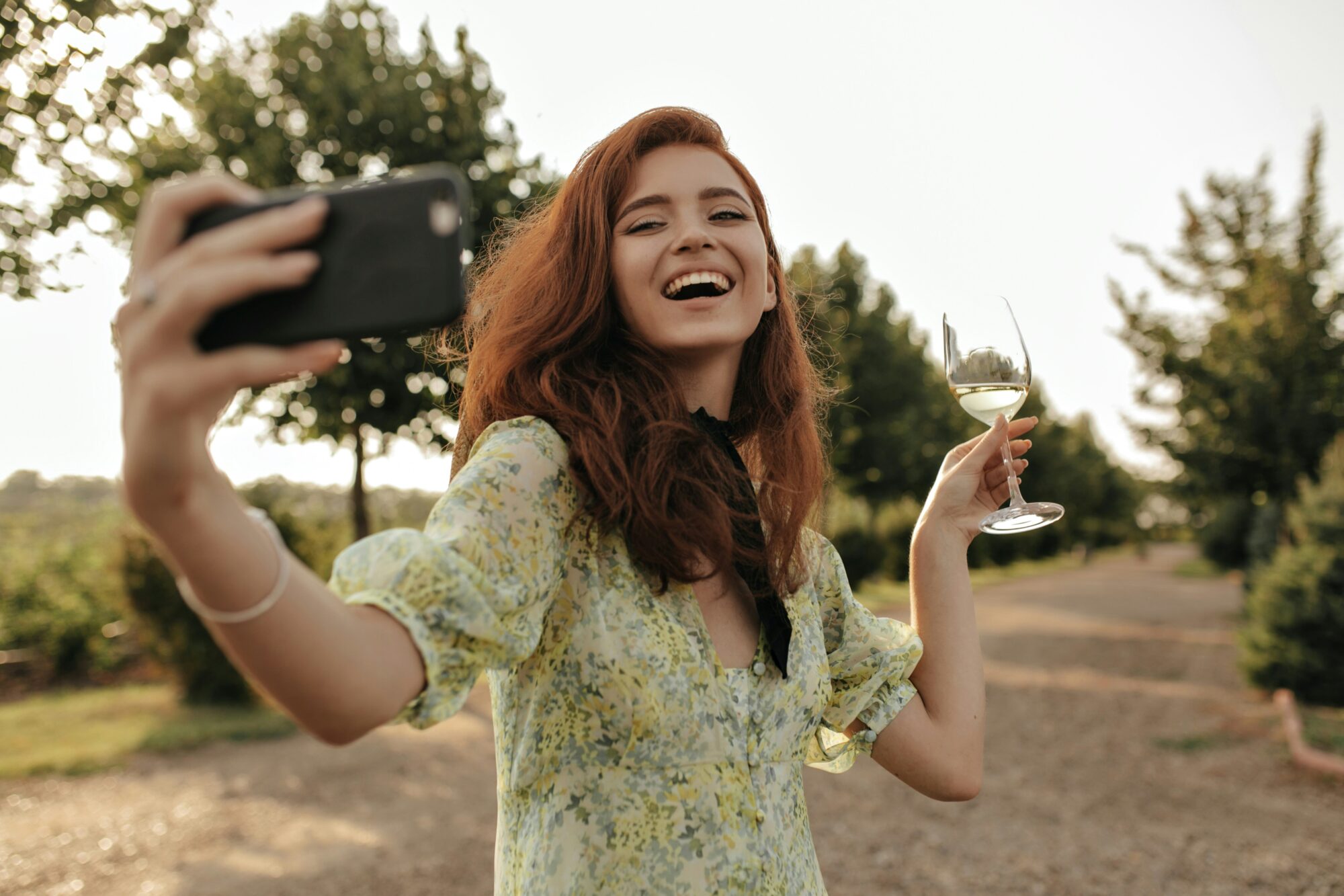 a woman taking a video message on zepeel with a wine glass